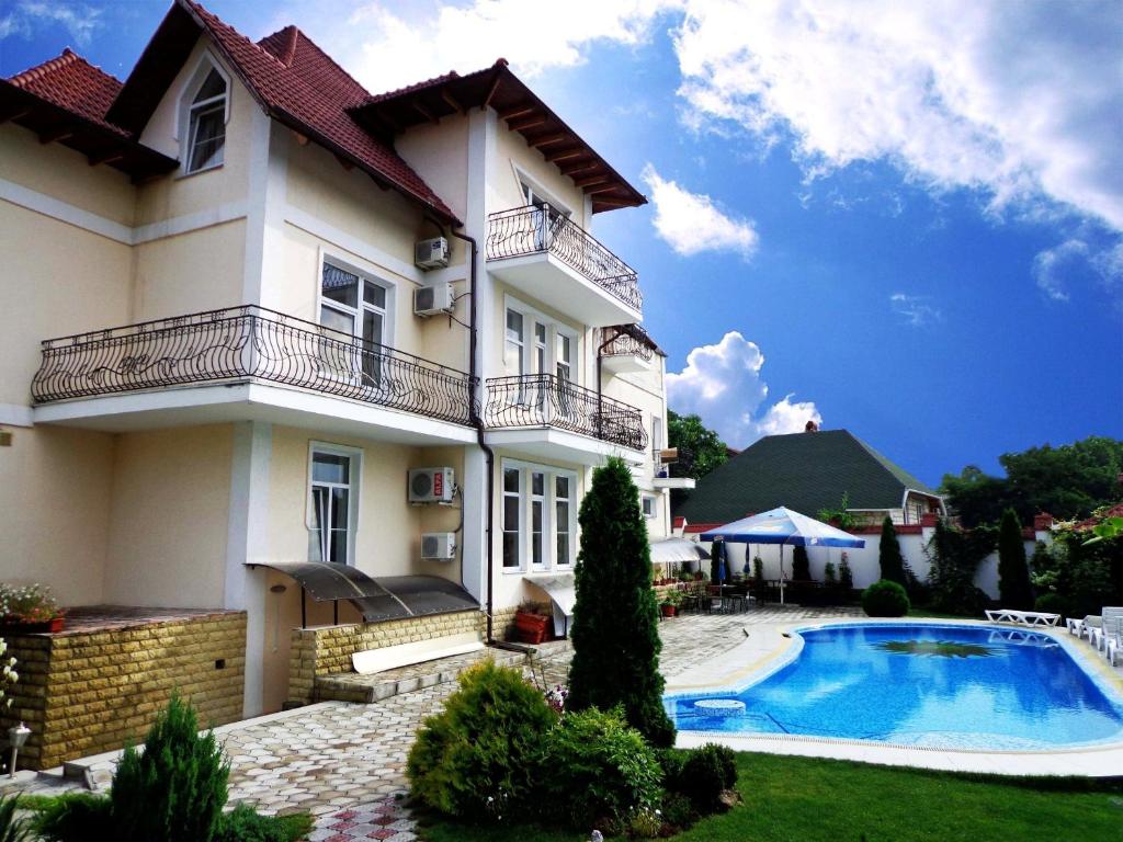 a house with a swimming pool in front of it at Edem Hotel in Chişinău