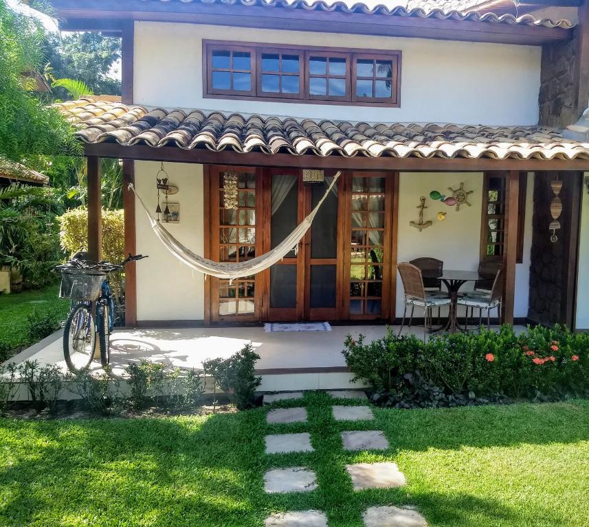 a house with a hammock in the yard at CASA EM ÓTIMO CONDOMINIO DE BUZIOS in Búzios