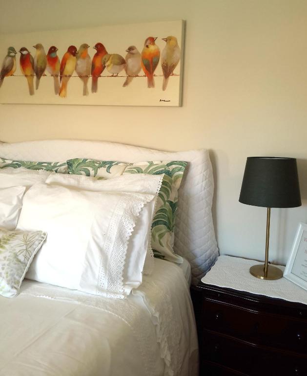 a bedroom with a bed with birds on the wall at Kika room Estoril in Estoril