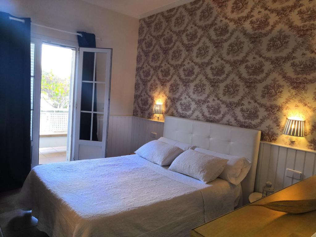 a bedroom with a large white bed with two lamps at Hotel Marisma Sancti Petri in Chiclana de la Frontera