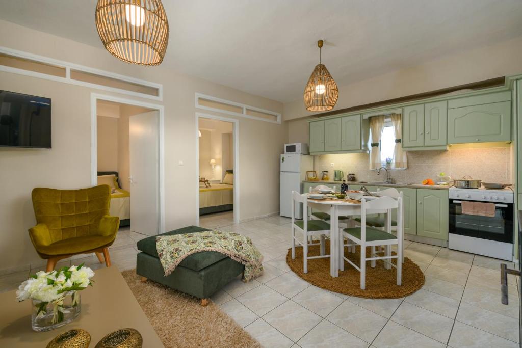 une cuisine avec des armoires vertes, une table et des chaises dans l'établissement Kouses Estate close to Matala, Komo beach & Faistos, à Kousés