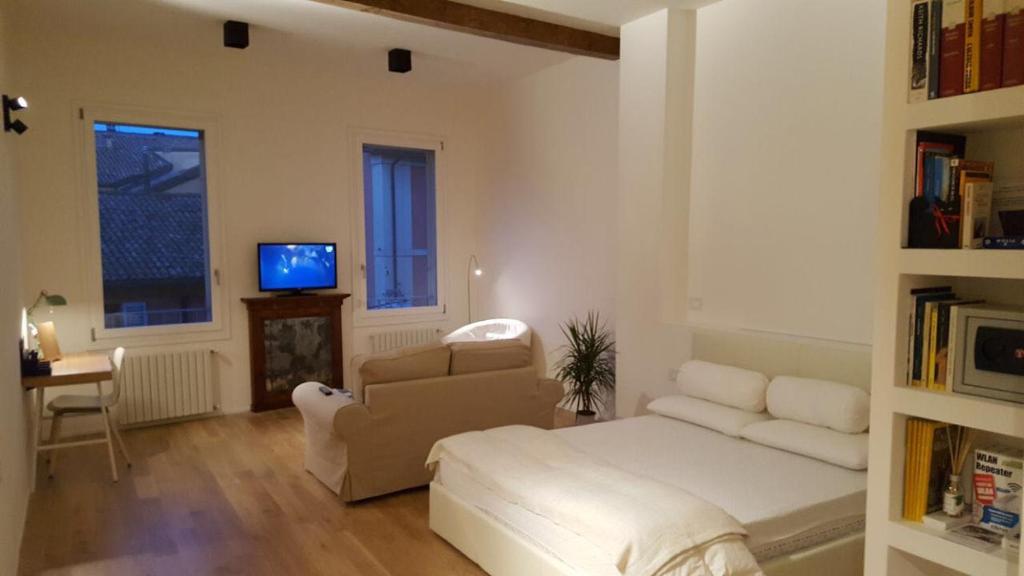 a living room with a white couch and a tv at Casa Tea in Bologna