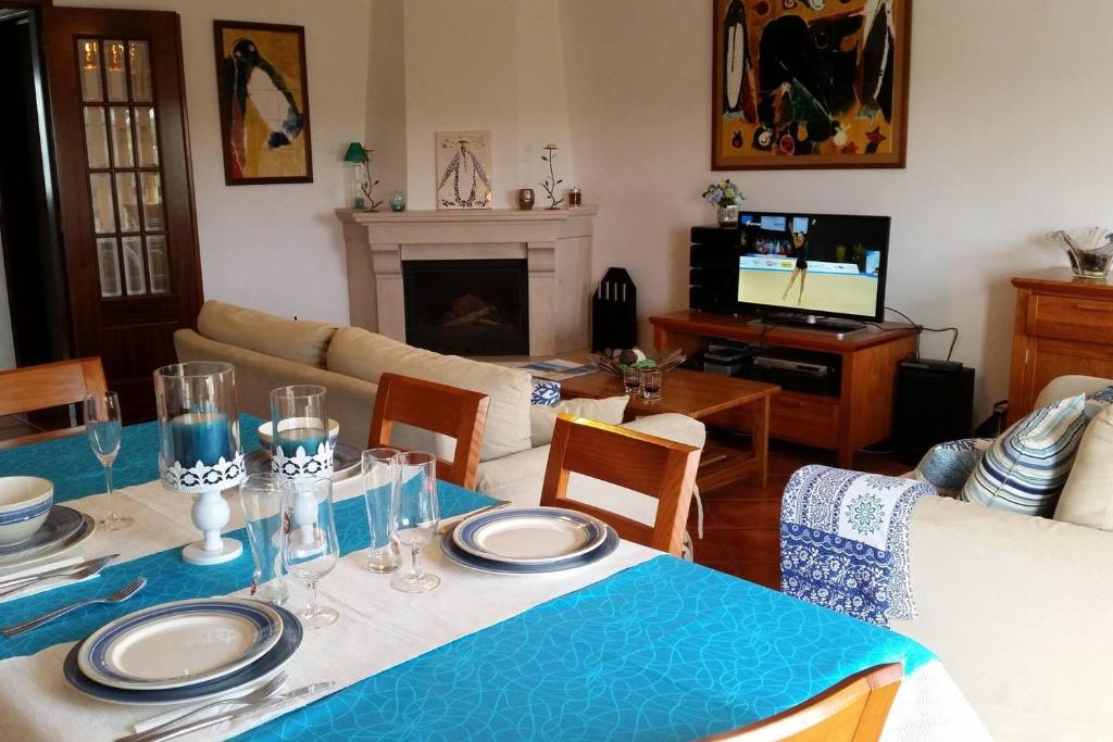 un salon avec une table et un chiffon bleu dans l'établissement SW Beach House Zambujeira do Mar, à Zambujeira do Mar
