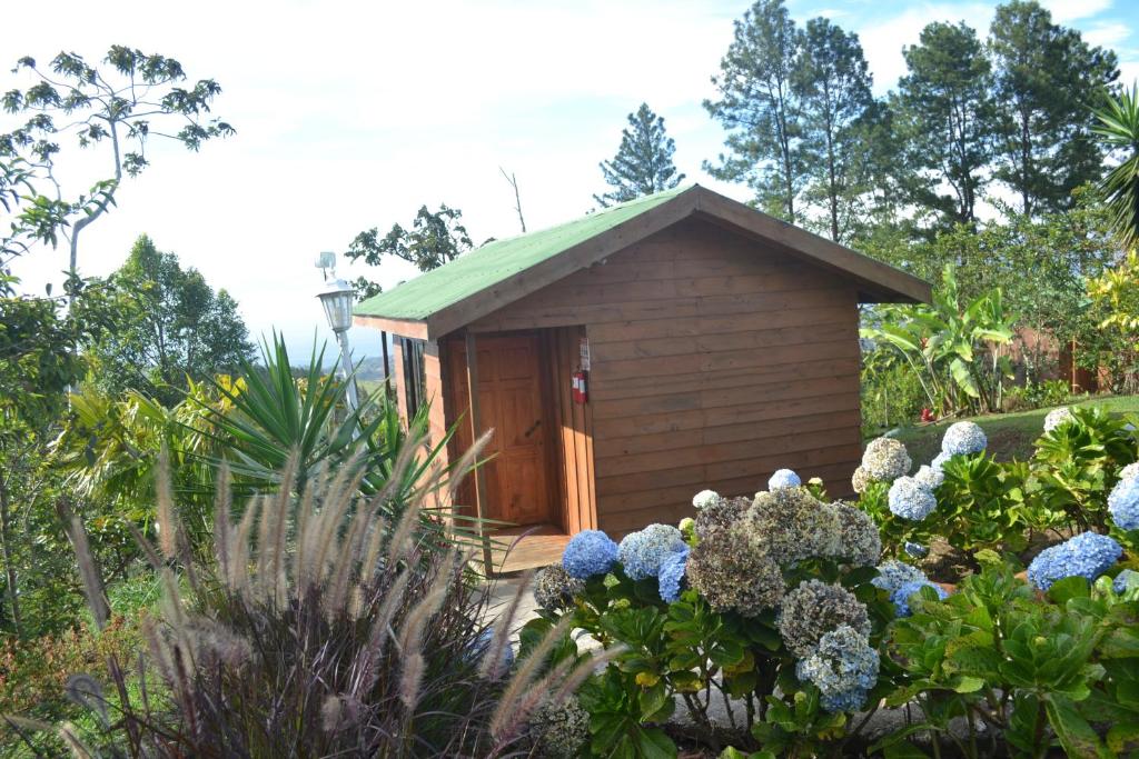 a small shed in a garden with flowers at Eco Granja Don Lolo in Quesada