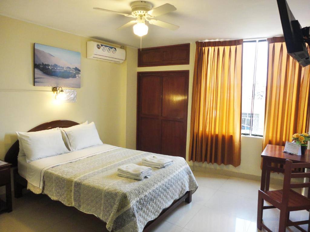 1 dormitorio con 1 cama y ventilador de techo en Hotel Torontel, en Ica