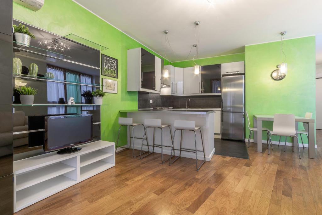 a kitchen with green walls and a table and chairs at Casa da Suite Fantasia in Milan