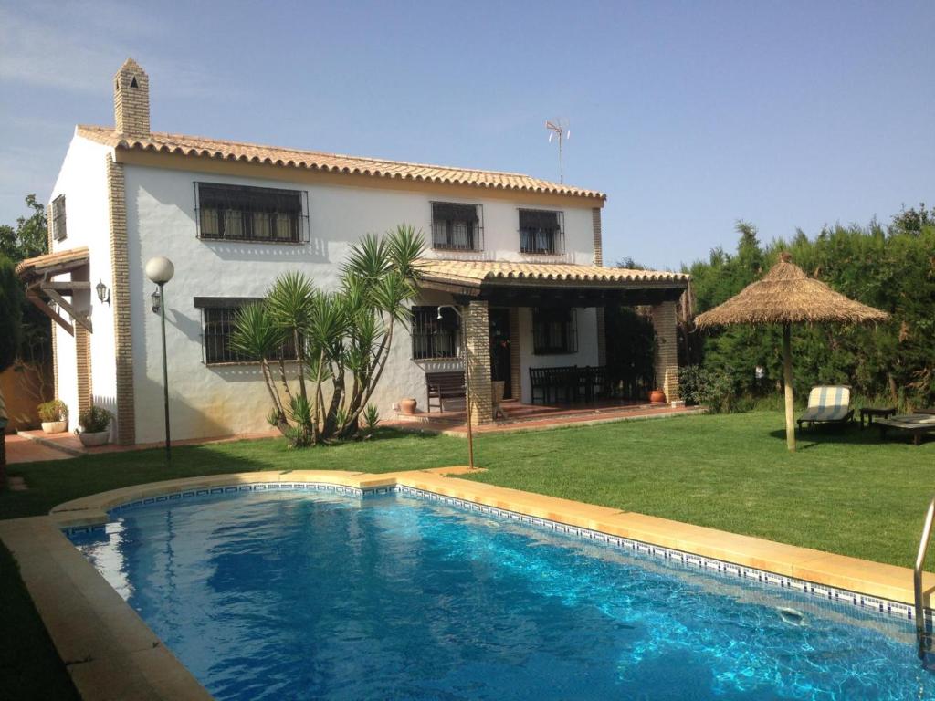 a house with a swimming pool in front of a house at Albara in Conil de la Frontera