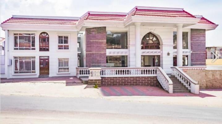 a large white building with a staircase in front of it at The Majestic Crown in Ooty