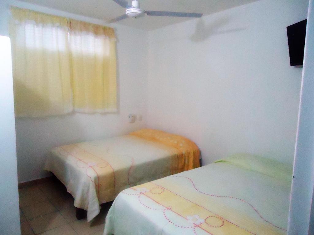 Habitación pequeña con 2 camas y ventana en Hotel Olas Huatulco, en Santa Cruz Huatulco
