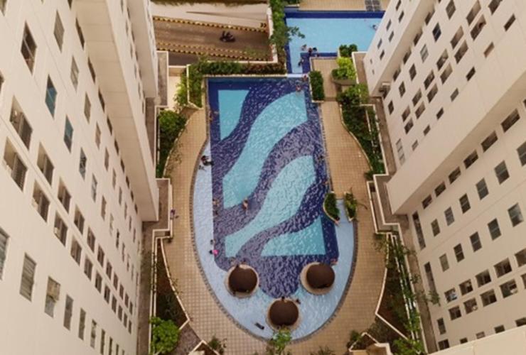 een uitzicht over een zwembad tussen twee gebouwen bij Channel Stay @ Bassura City Apartment in Jakarta