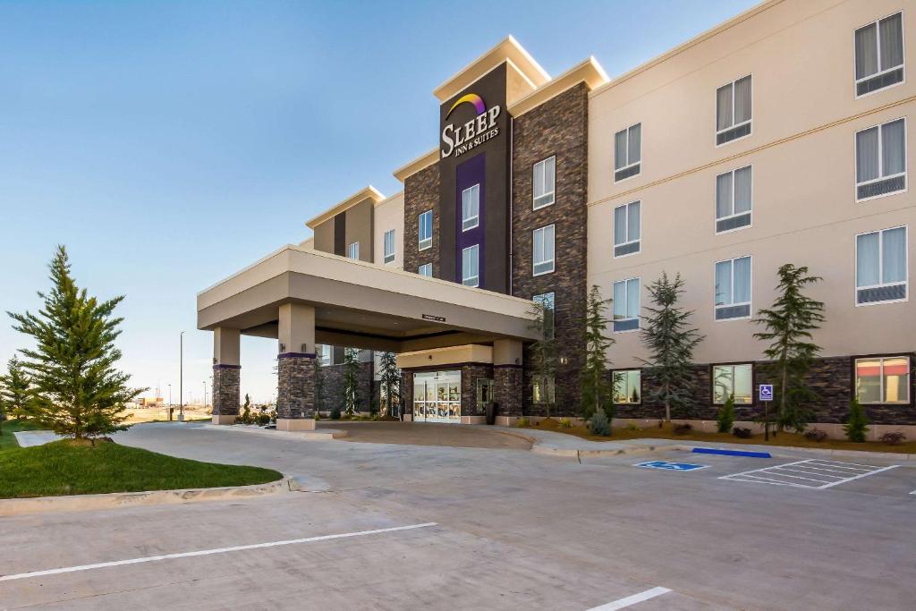 a hotel with a parking lot in front of it at Sleep Inn & Suites Yukon Oklahoma City in Yukon