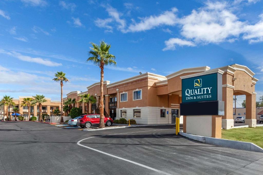 a sign in front of a building with palm trees at Quality Inn & Suites near Downtown Mesa in Mesa