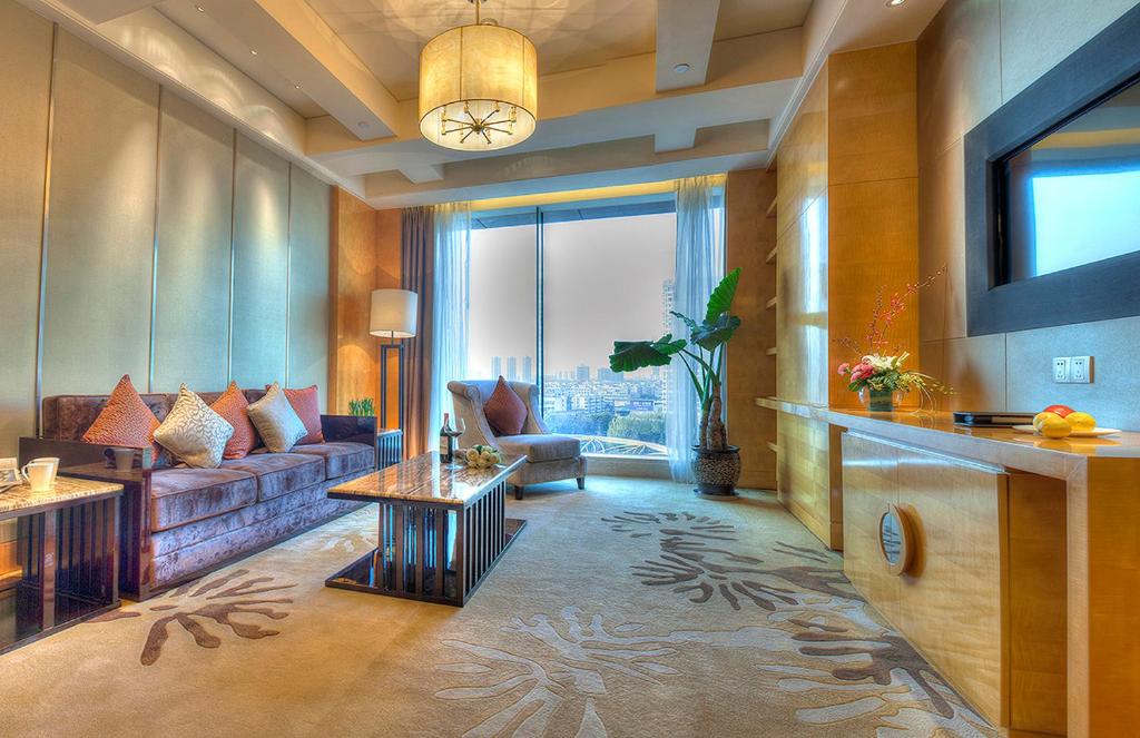 a living room with a couch and a tv at Felton Grand Hotel Chengdu in Chengdu