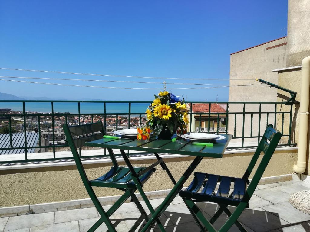 einen Tisch und zwei Stühle auf einem Balkon mit einem Tisch und Blumen in der Unterkunft City house in Campofelice di Roccella
