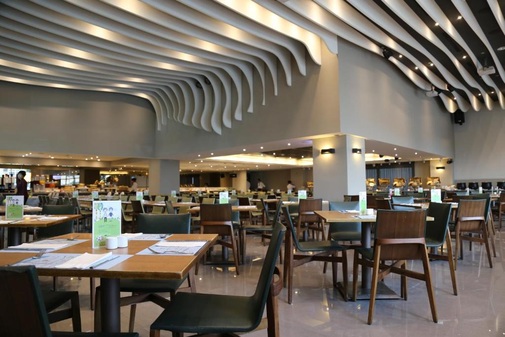 a dining room with wooden tables and chairs at Taichung Harbor Hotel in Wuqi