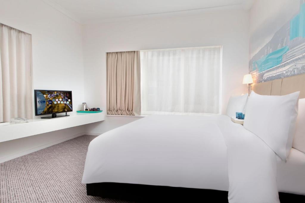 a hotel room with a bed and a television at OZO Wesley Hong Kong in Hong Kong