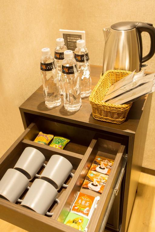 a drawer in a cabinet filled with food and water bottles at Just Live Inn-Taipei Station in Taipei