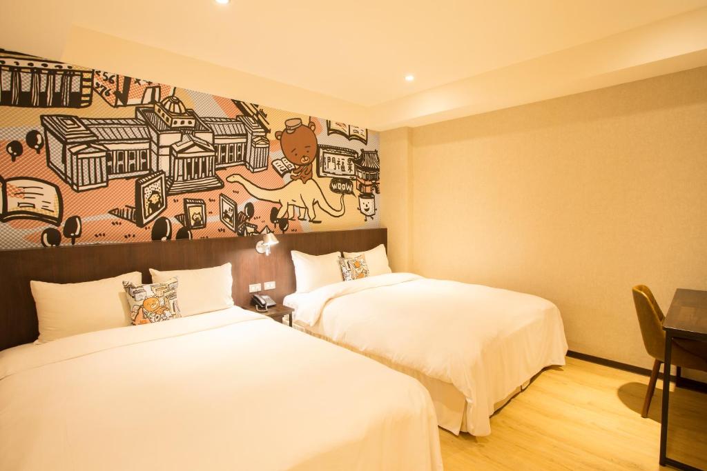 two beds in a room with a mural on the wall at Just Live Inn-Taipei Station in Taipei