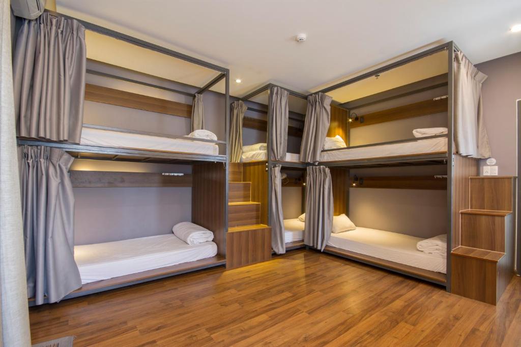 three bunk beds in a room with wood floors at Light House Hostel in Da Nang