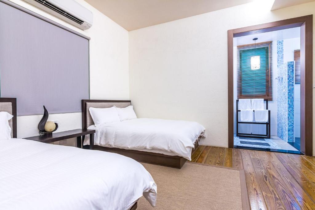 a hotel room with two beds and a window at Ville Greensward in Taitung City