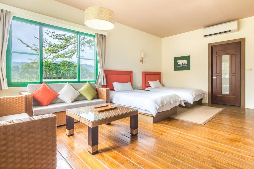 a hotel room with two beds and a couch at Ville Greensward in Taitung City