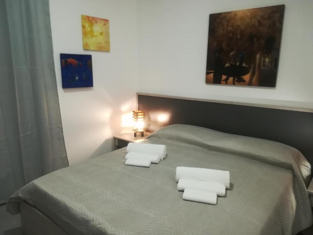 Una cama con dos toallas blancas encima. en DIMORA DELL'ARTISTA 2, en Lecce