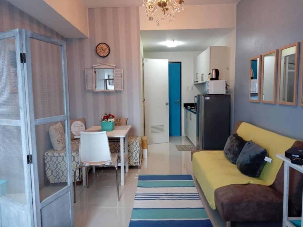 ein Wohnzimmer mit einem gelben Sofa und einer Küche in der Unterkunft Wow View Princeton near LRT Magnolia Mall Wi-Fi TV in Manila