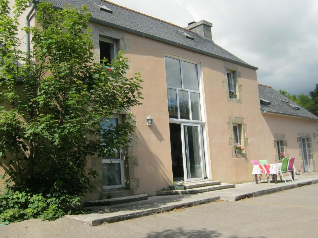 a house with two chairs sitting outside of it at Maison De Campagne - Porte Brest Ouest. in Guilers