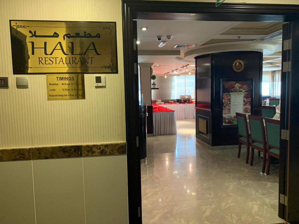 a lobby with a restaurant with a sign on the wall at Hala Inn Hotel Apartments - BAITHANS in Ajman 