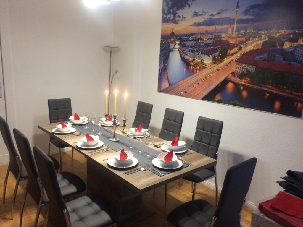 a dining room with a long table with chairs and a painting at City-Apartment Zille in Berlin