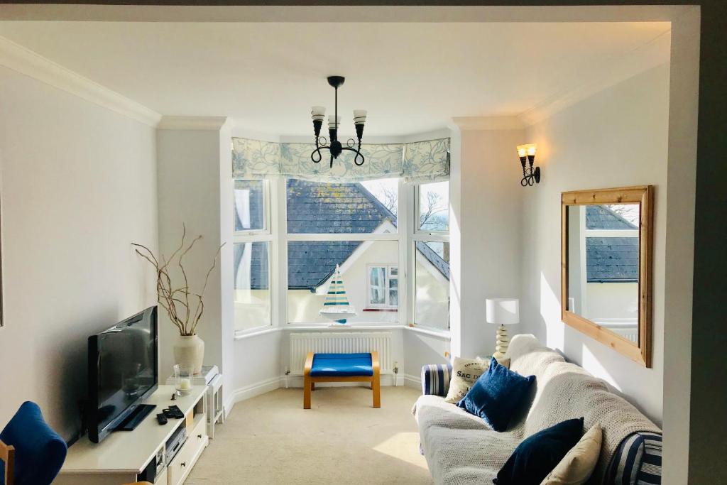 a living room with a couch and a tv and a window at Southgrove View, Family Holiday Cottage in Ventnor