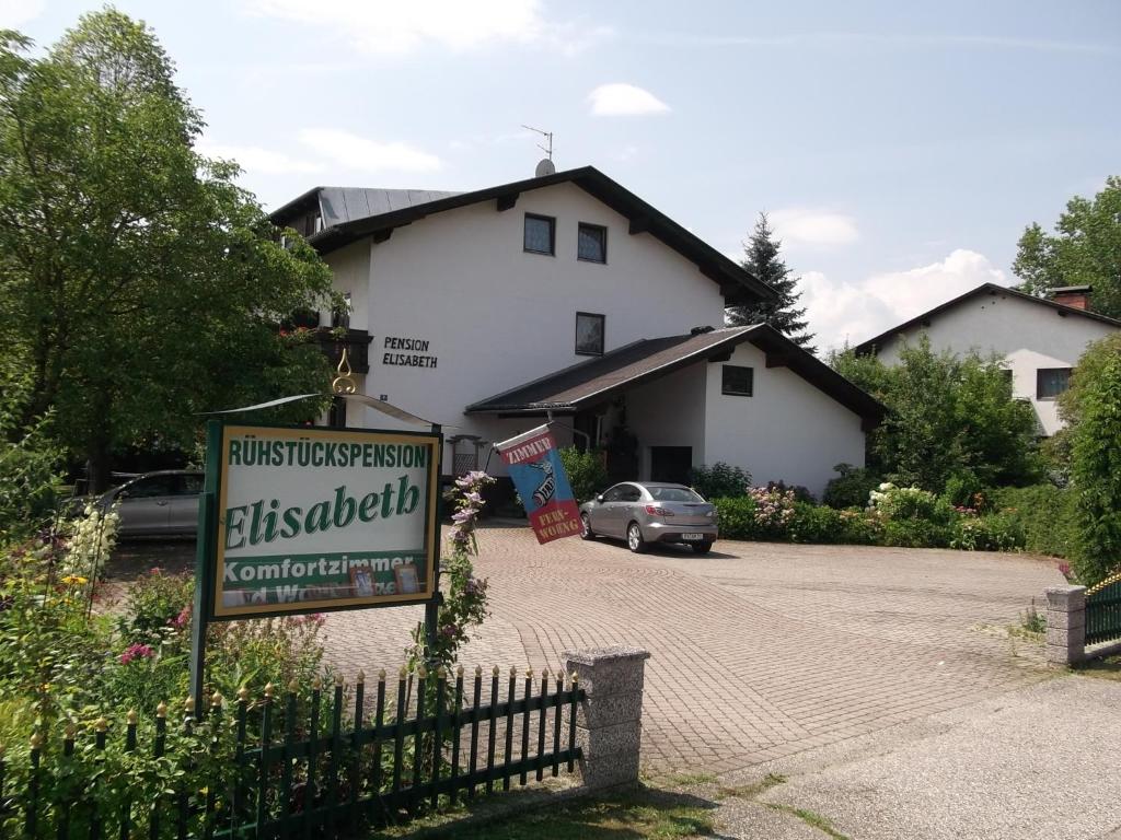 ein Schild vor einem Haus mit einem Gebäude in der Unterkunft Pension Elisabeth in Sankt Kanzian am Klopeiner See
