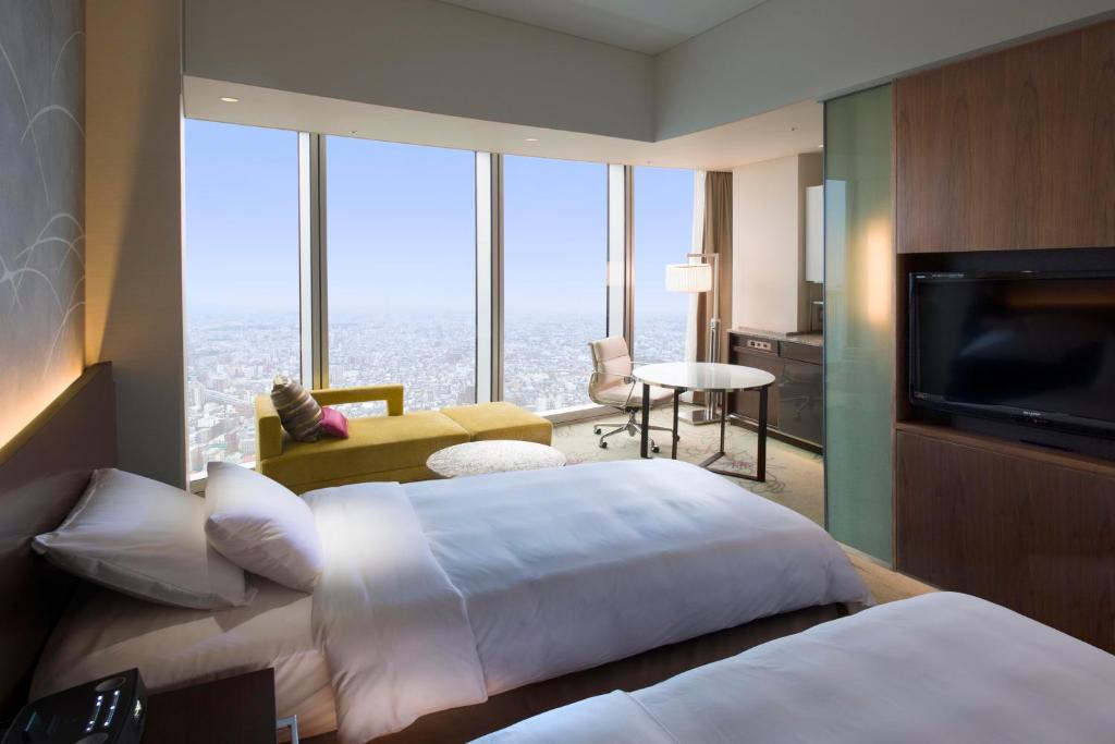 a hotel room with two beds and a television at Osaka Marriott Miyako Hotel in Osaka