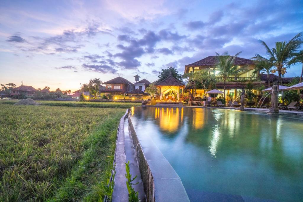 a villa with a pool in front of a house at Cendana Resort & Spa by Mahaputra in Ubud