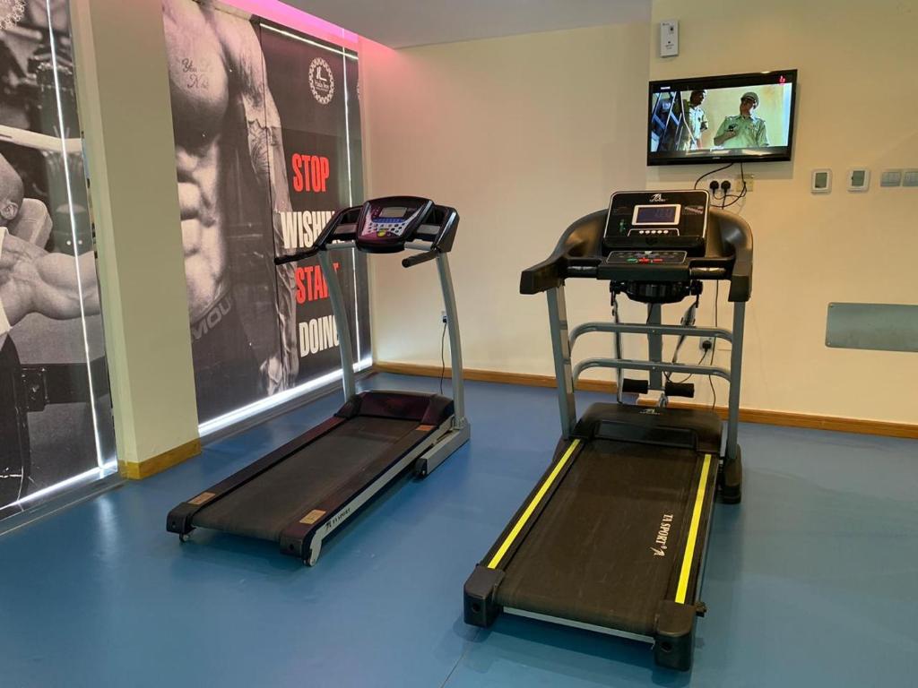 a gym with two exercise bikes and a treadmill at Hala Inn Hotel Apartments - BAITHANS in Ajman 