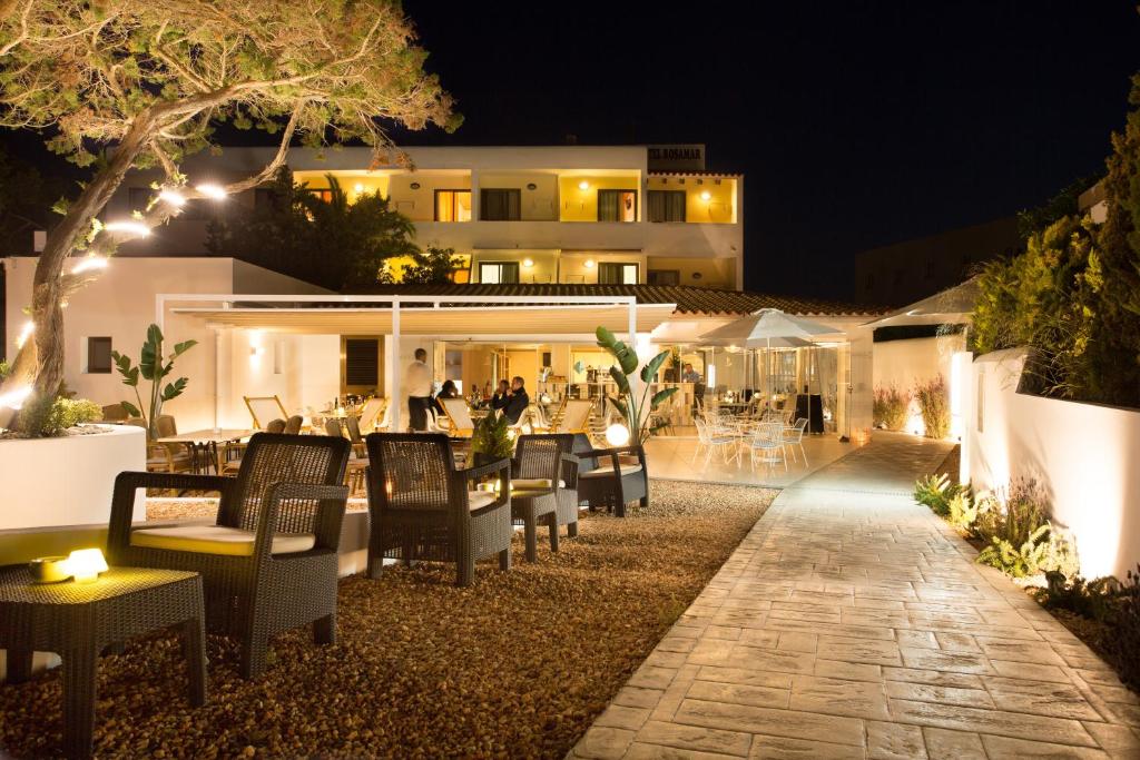 a restaurant with tables and chairs at night at Hotel Rosamar - Emar Hotels in Es Pujols