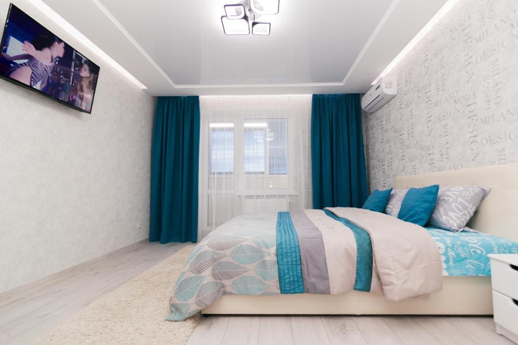 1 dormitorio con 1 cama con cortinas azules en проспект Михайла Лушпи, en Sumy