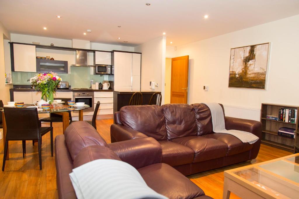a living room with a leather couch and a table at City 3 Bedroom Ensuited apartment with parking in Dublin
