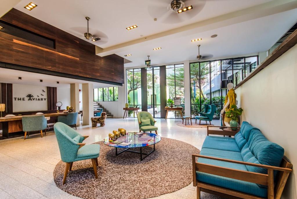 a living room with a blue couch and chairs at The Aviary Hotel in Siem Reap