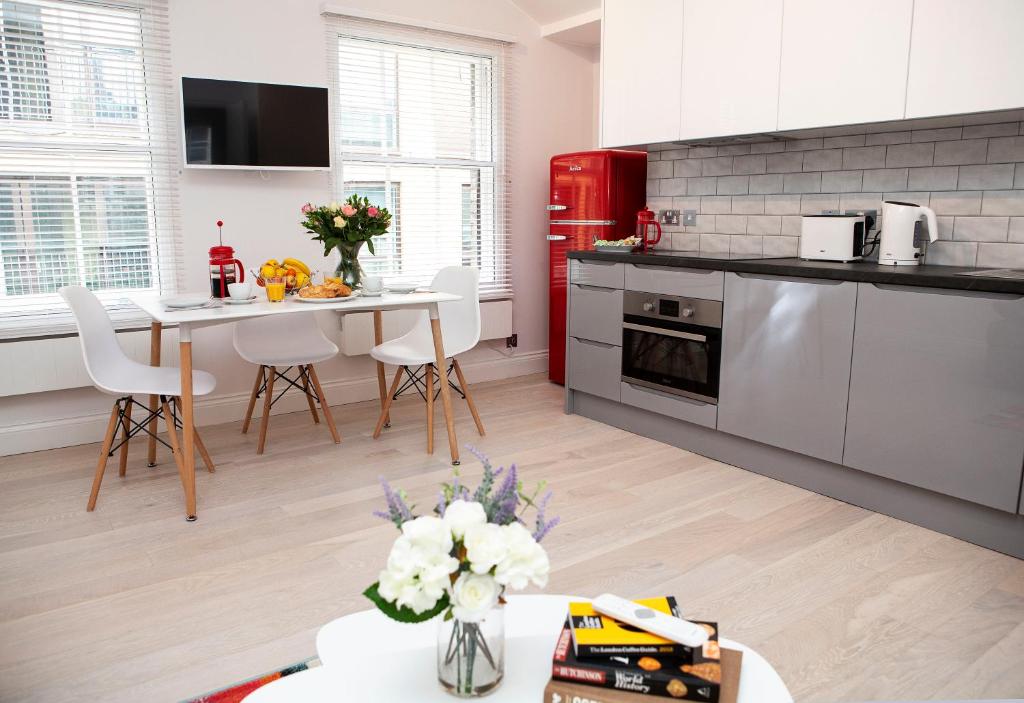 a kitchen with a table and a red refrigerator at Soho Suites by Indigo Flats in London