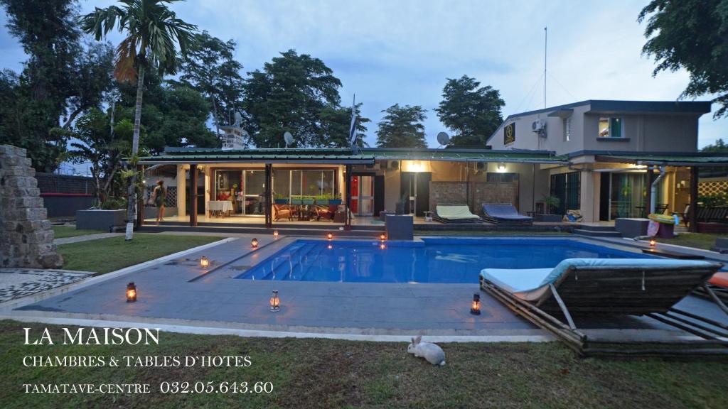 a house with a swimming pool in front of a house at La Maison in Toamasina