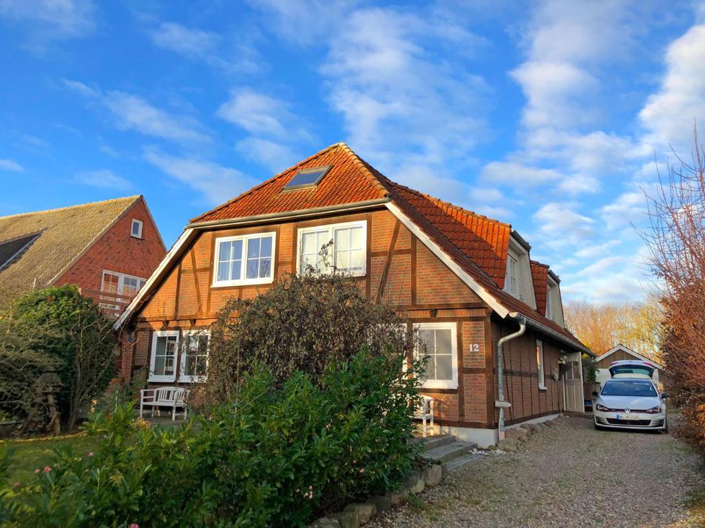 a house with a car parked in front of it at Tolle Ferienwohnung in schönem Bauernhaus in Fehmarn