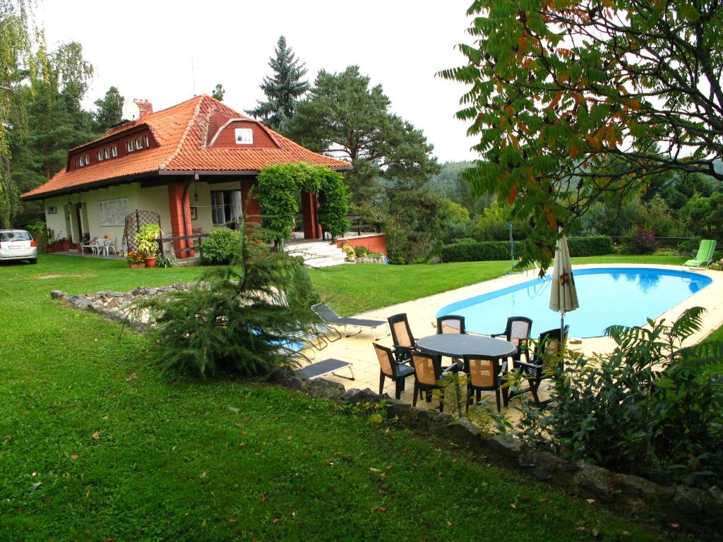Villa Blanka في Horní Podkozí: منزل به طاولة وكراسي بجوار حمام سباحة