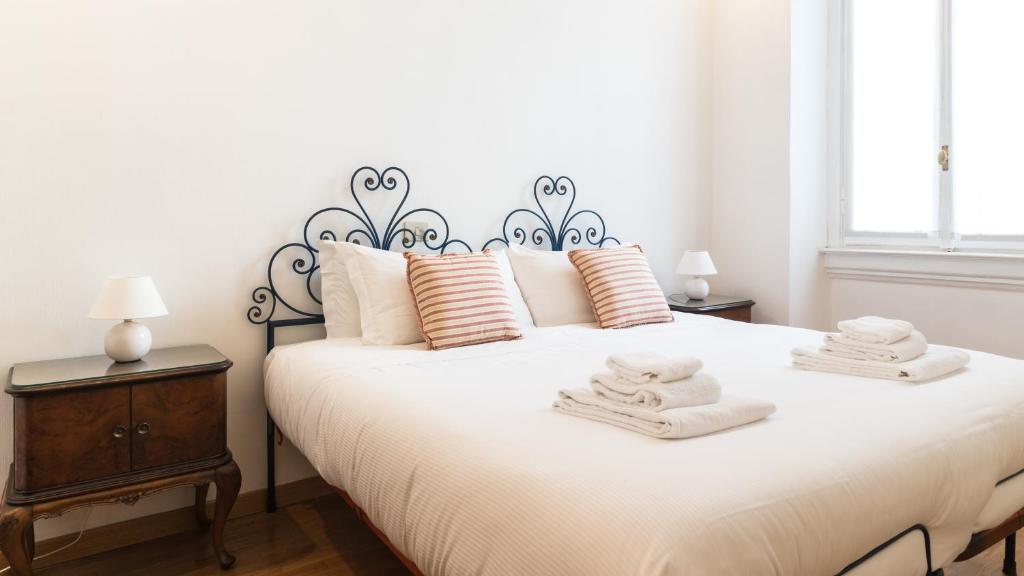 una camera da letto con un grande letto bianco con asciugamani di Italianway - Sardegna 59 a Milano