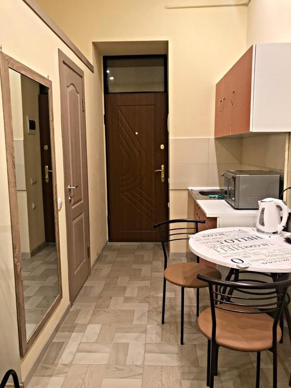 a small kitchen with a table and chairs and a door at Apartament at Park in Lviv