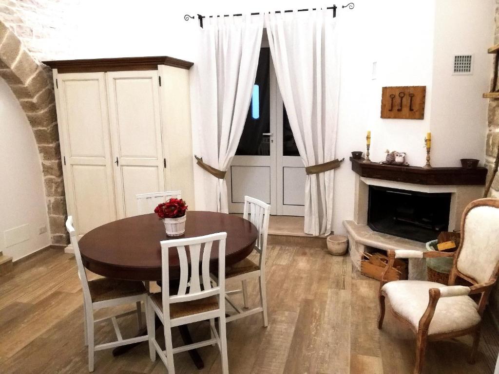 ein Esszimmer mit einem Tisch, Stühlen und einem Kamin in der Unterkunft Oltre le mura b&b in Bitonto
