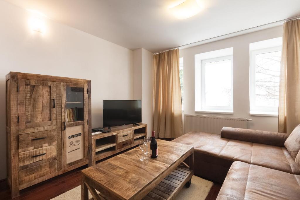 a living room with a couch and a table at Apartment SnowWhite in Starý Smokovec