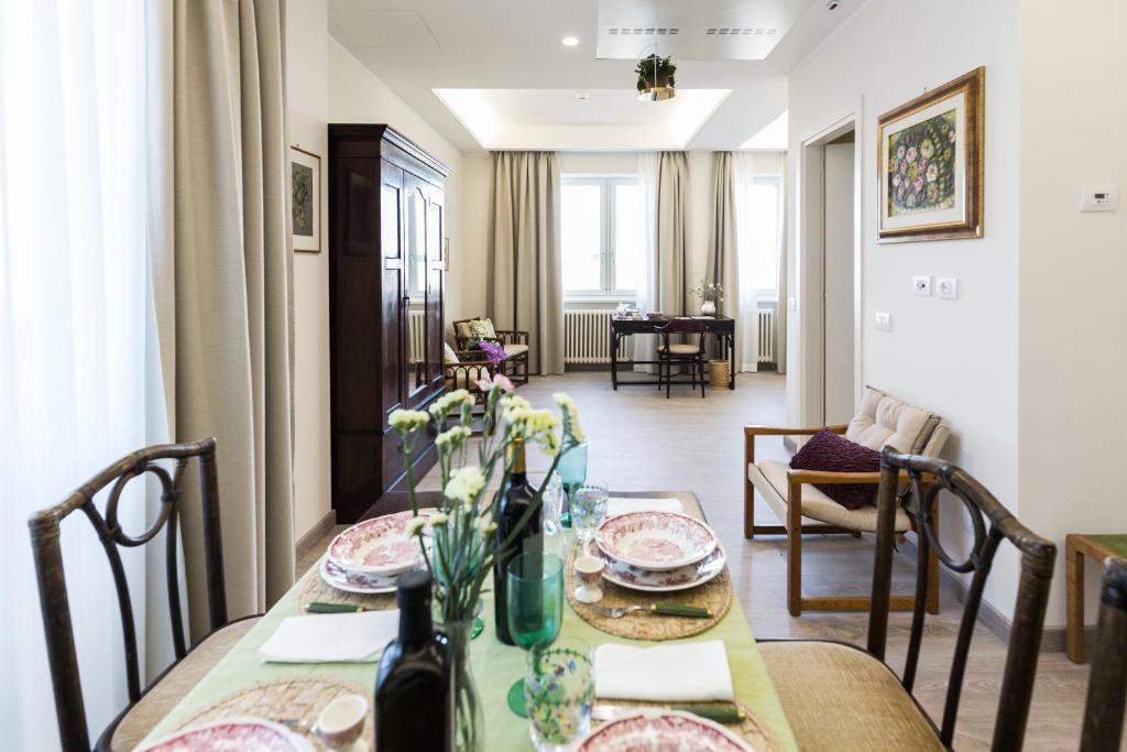 ein Esszimmer mit einem Tisch und ein Wohnzimmer in der Unterkunft Villa Cavalletti Appartamenti in Grottaferrata