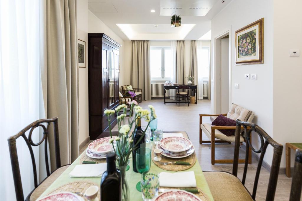 a dining room with a table and a living room at Villa Cavalletti Appartamenti in Grottaferrata