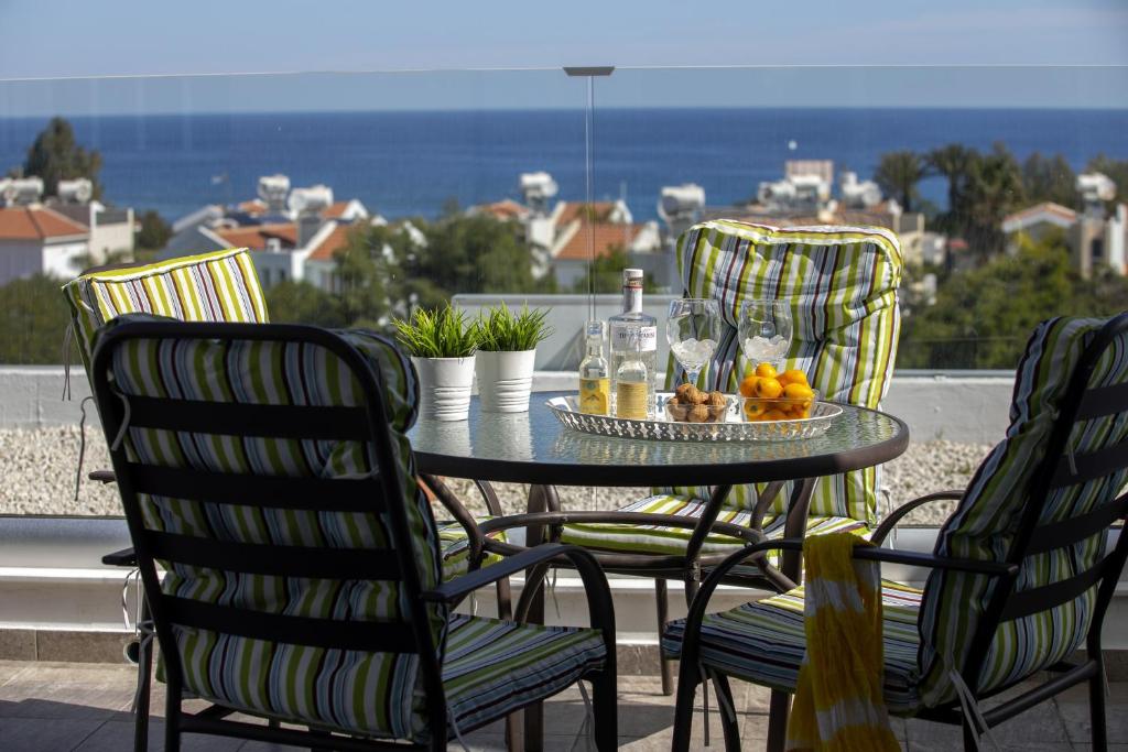 a table with two chairs and a table with fruit on it at Green Bay Penthouse 2 in Protaras